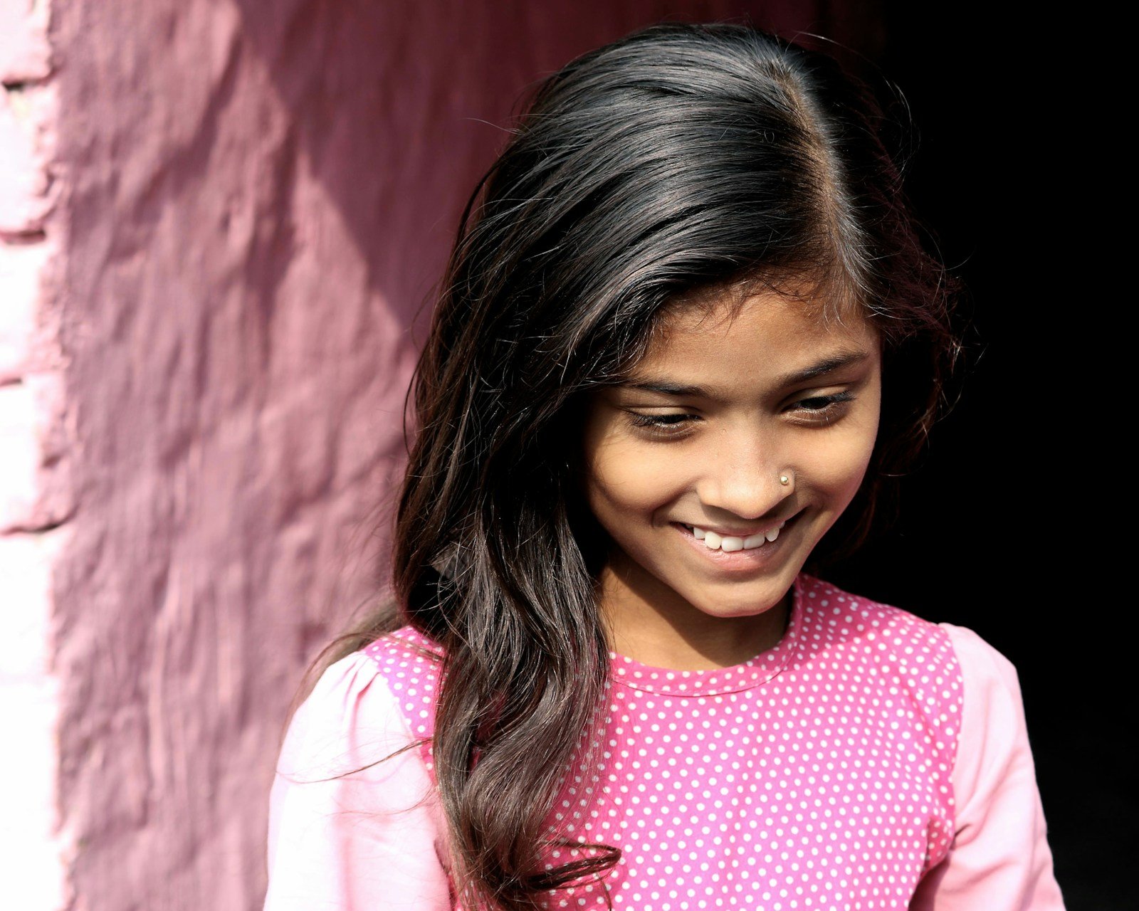 Smiling girl standing near a wall