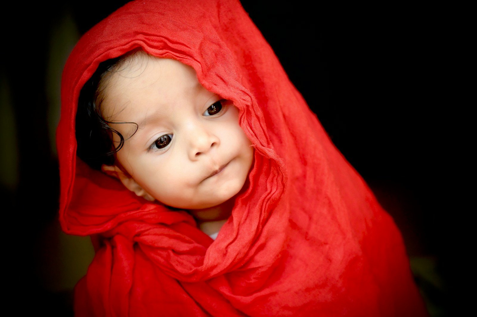 Infant resting in a red hoodie