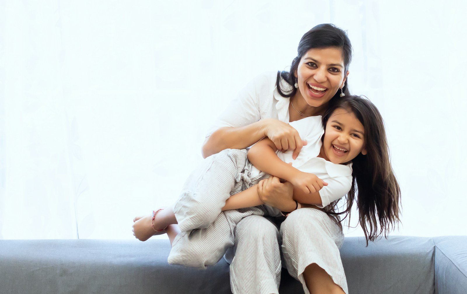 Mother holding her laughing child at home